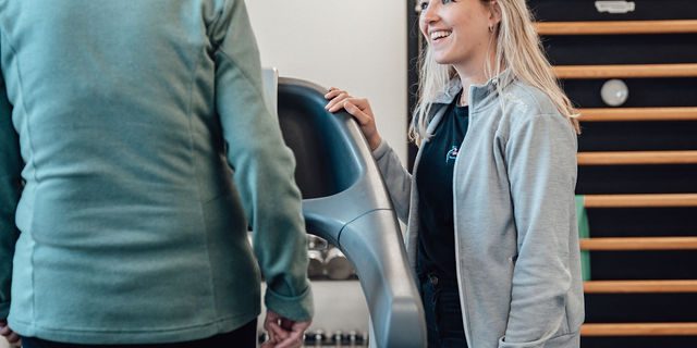 Mevrouw van Duin heeft artrose en loopt op de loopband onder begeleiding van Fysiotherapeut Laura in de oefenzaal.