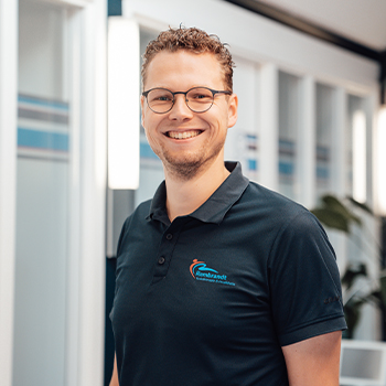 Profielfoto van Bob Verweij die als fysiotherapeut poseert voor de camera in een grijze hoodie en blauwe polo