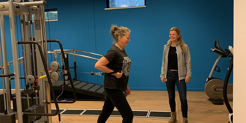 Jennie voert oefeningen uit in de oefenzaal onder begeleiding van fysiotherapeut Manon voor haar revalidatietraject na een heupoperatie.