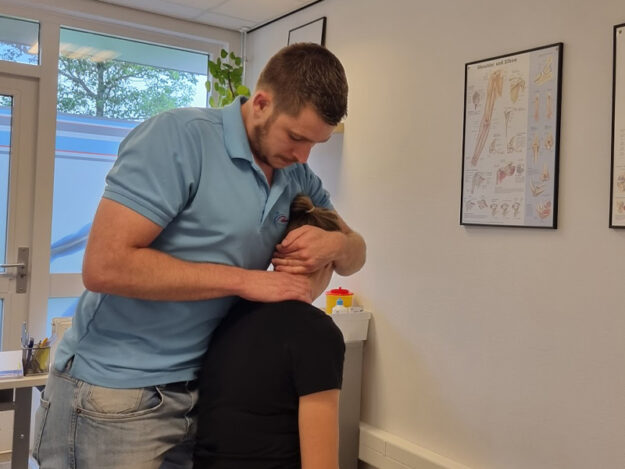 Vrouw heeft nekpijn tijdens het auto gekregen en zit nu bij de fysiotherapeut terwijl hij haar nek behandelt.