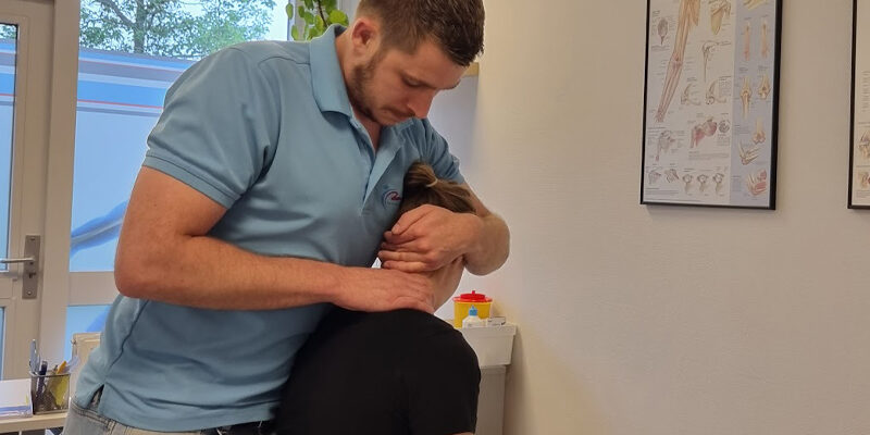 Vrouw heeft nekpijn tijdens het auto gekregen en zit nu bij de fysiotherapeut terwijl hij haar nek behandelt.