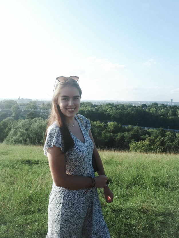 Foto van Anna Kooistra in een zomerjurk met zonnebril op die last heeft van kaakpijn