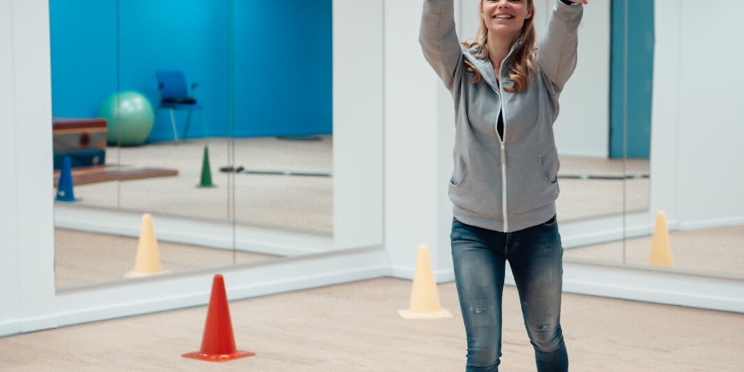 Bewegen Een vrouw is aan het bewegen. Ze staat in een oefenzaal en ze gooit een bal omhoog.