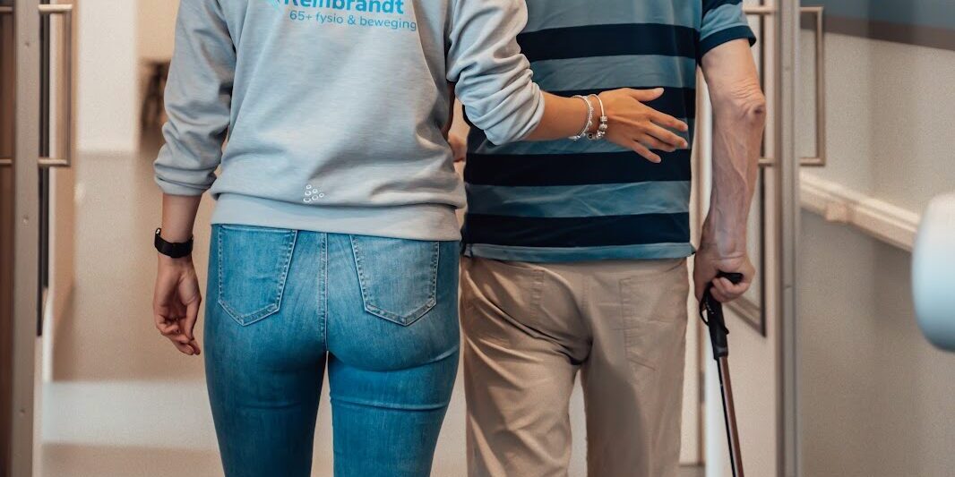 Mevrouw is met oudere man aan het lopen om verminderen van valrisico’s bij ouderen