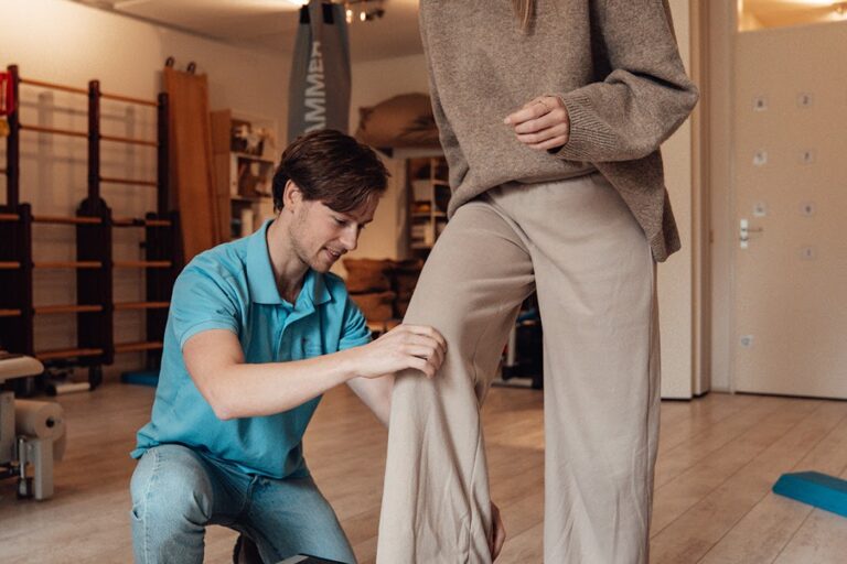 Fysiotherapeut doet oefening met patiënt in zaal