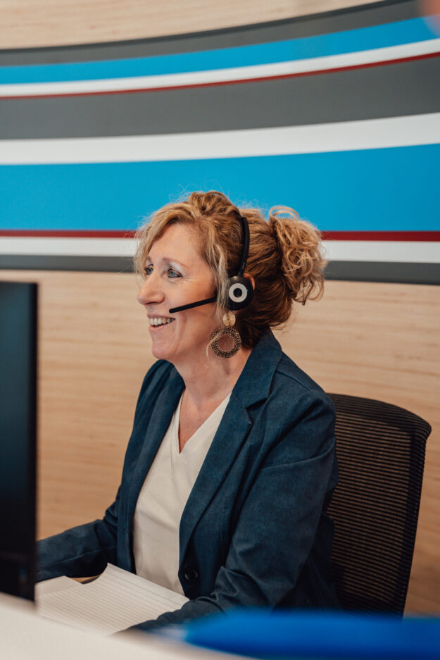Nancy met headset achter computer Collega Nancy met headset achter computer